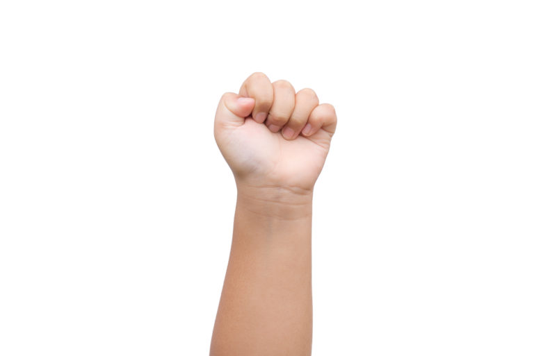 Children Boy hand showing fist as rock paper sign on white background