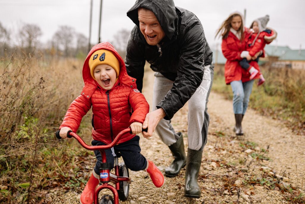 dad helping child ride bike