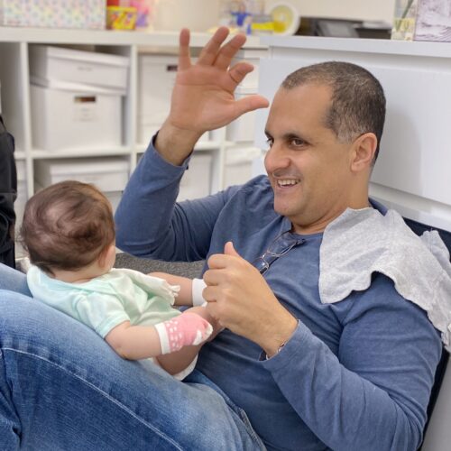 father teaching baby to sign