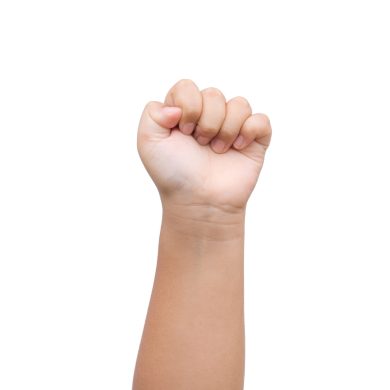 Children Boy hand showing fist as rock paper sign on white background